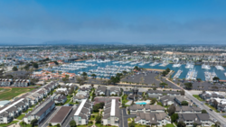 Aerial view of a coastal residential community with a large marina filled with white boats.