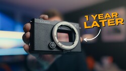 Panasonic Lumix mirrorless camera body held in hand, shown from front with lens mount exposed.