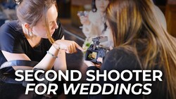 Female videographer operating a mirrorless camera while another woman looks on during a production setup.