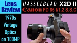 Hasselblad X2D II camera with Canon FD 85mm f/1.2 S.S.C lens mounted, held in hands against pink background.