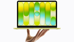 Laptop displaying a vibrant wallpaper with gradient-filled pill shapes in yellow, green, cyan, and white tones.
