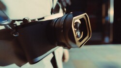 Close-up of a camera lens with a gold square filter holder mounted on the front.
