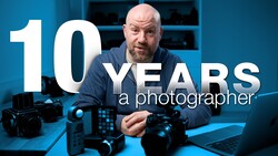 Photographer with professional camera equipment at desk with blue lighting and text overlay stating "10 YEARS a photographer."