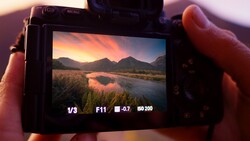 Camera LCD screen displaying landscape photo with exposure settings: 1/3 shutter speed, F11 aperture, -0.7 exposure compensation, ISO 200.