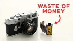 Vintage rangefinder camera next to a roll of film with red text reading "Waste of Money."