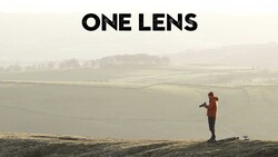 Runner in orange jacket jogging across rolling hills in misty morning light.