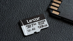 Lexar Silver Plus 128GB microSD card with V30, U3, and A2 speed class ratings next to a card reader