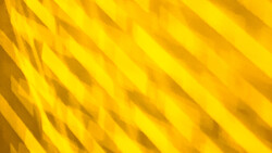 Abstract yellow diagonal lines creating a textured pattern with shadow and light variation