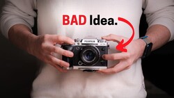 Person holding a rangefinder film camera with text overlay reading "BAD idea" and a red arrow pointing to the camera.