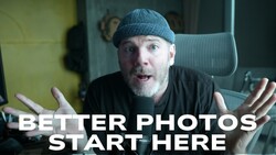 Man wearing a beanie in an office setting gestures expressively while speaking to camera.