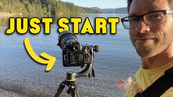 Photographer with camera mounted on gimbal stabilizer by a lakeside, demonstrating video equipment setup.