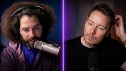 Two male podcast hosts seated at microphones during a recording session with purple lighting dividing the frame.