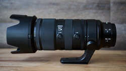 Nikon S-line telephoto zoom lens with hood and focusing mechanism mounted on wooden surface