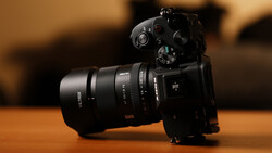 Black mirrorless camera with attached telephoto lens on wooden surface