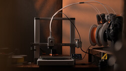 3D printer with filament spool and monitoring headphones on warm-toned studio backdrop