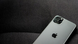 Silver iPhone 11 Pro with quad camera system on dark textile surface