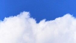Puffy white cumulus clouds against a vibrant blue sky