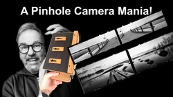 Enthusiast holding a wooden pinhole camera with sample black and white photographs displayed
