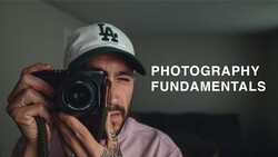 Photographer holding a Leica rangefinder camera, wearing LA Dodgers cap