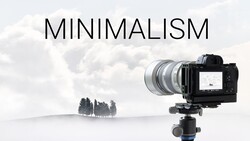 Mirrorless camera on tripod with telephoto lens pointed at minimalist landscape with three trees