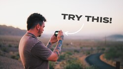 Photographer holding smartphone to capture landscape at golden hour