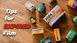 Collection of expired film stock boxes arranged on wooden surface with text overlay 'Tips for EXPIRED Film'