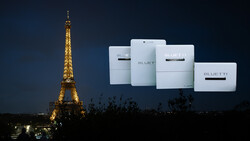 Eiffel Tower illuminated at night with white Bluetti portable power stations displayed overhead