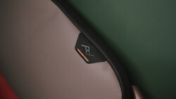 Close-up of a camera strap with brand logo and orange accent stitching