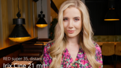 Portrait of woman with blonde wavy hair wearing magenta floral shirt against warm interior lighting