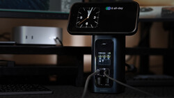 iPhone mounted on articulating stand displaying analog clock widget above studio lighting equipment