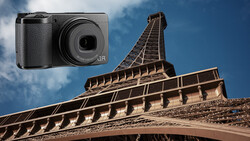 Ricoh GR compact camera overlaid on architectural photograph of Eiffel Tower