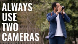 Photographer holding camera to face with text overlay reading 'ALWAYS USE TWO CAMERAS'