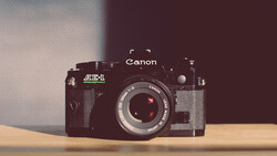 Canon AE-1 35mm film camera with Auto-Dial accessory on wooden surface