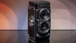 Chuzhao twin-lens reflex camera with dark leather covering displayed against warm and cool gradient lighting