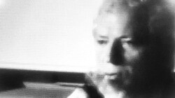 Black and white portrait of a person in profile holding a rifle