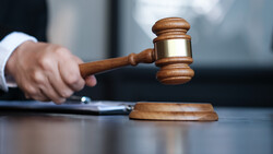 Judge striking wooden gavel on sound block during courtroom proceeding