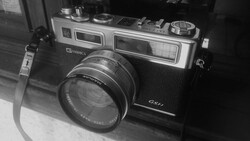 Vintage rangefinder camera with dual viewfinders and standard lens in black and white