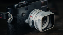 Leica M rangefinder camera with silver lens and hood on dark background