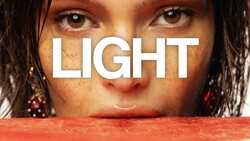 Close-up portrait of woman's face with word 'LIGHT' overlaid in white typography
