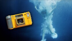 Yellow waterproof camera positioned above underwater scene with ascending air bubbles