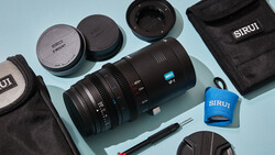 SIRUI lens and accessories laid out on light blue background with carrying cases and lens caps