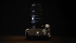 Vintage film SLR camera with telephoto lens against black background, studio lighting