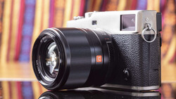 Rangefinder camera with black lens on colorful striped background