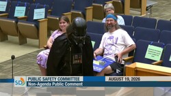 Person in Darth Vader costume speaking at Public Safety Committee meeting podium