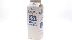 Lucerne skim milk carton with blue cow logo on white background