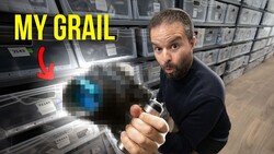 Photographer holding a pixelated camera in a warehouse full of photography equipment boxes
