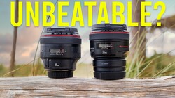 Two Canon lenses displayed side-by-side on wooden surface with natural landscape background