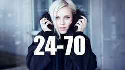 Portrait of blonde woman in black hooded jacket with fur-lined hood