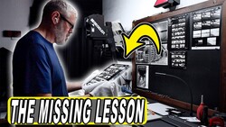 Photographer reviewing contact sheets and negatives at a light table in a darkroom setup