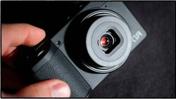 Handheld gimbal stabilizer with red indicator light held in photographer's hand